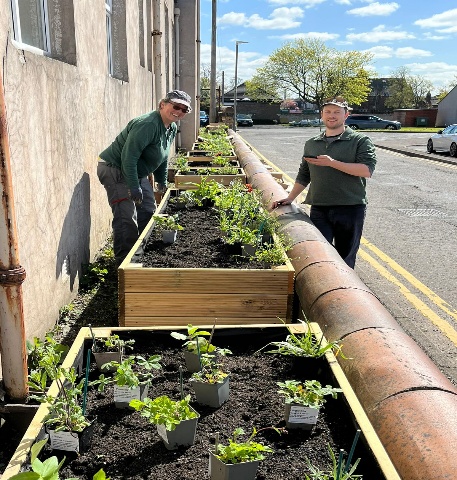 Planting beds being created beside a workplace building